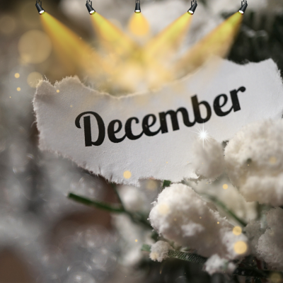 A snowy background with lights pointing at the word December