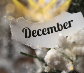 A snowy background with lights pointing at the word December