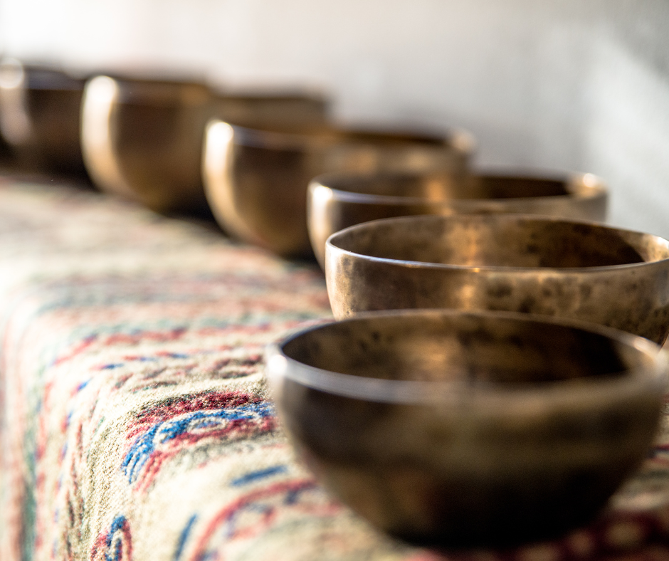 6 singing bowls arranged on a embroidered cloth